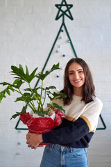 pretty woman holding plant christmas present
