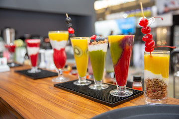 A set of different colored smoothies in glasses on wooden background. healthy food