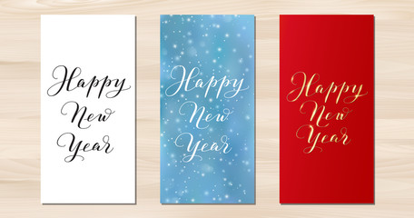 Happy New Year vertical cards. Hand drawn calligraphy isolated on white, gold on red. Blue background with falling snow