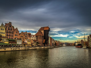 Fototapeta na wymiar Famous medieval crane in the Gdansk , Poland in the evening with scenic dark blue cloudy sky