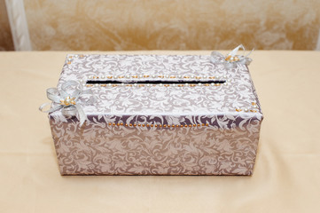 Box for gifts on the table of the newlyweds. Planting and tools for newlyweds, a honeymoon box for gift envelopes with money.