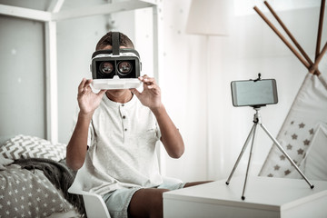Futuristic technology. Pleasant smart boy wearing 3d glasses while recording a video for his blog