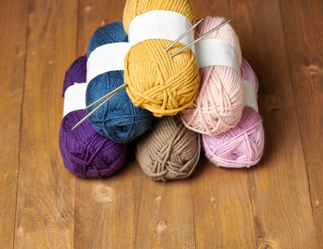 colorful wool yarn for knitting on wooden background