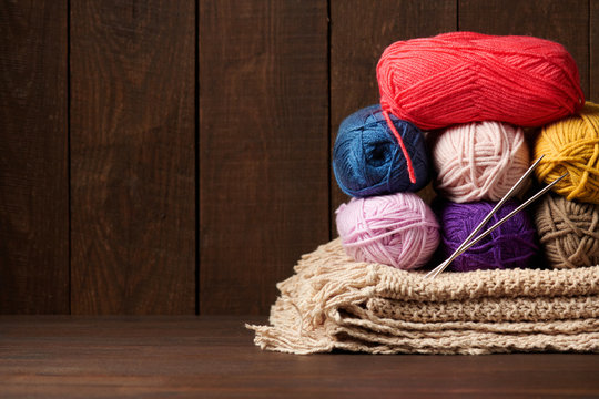 balls of woolen yarn for knitting on wooden background