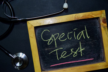 The words Special Test handwriting on chalkboard on top view. Alarm clock, stethoscope on black background. With education, medical and health concepts
