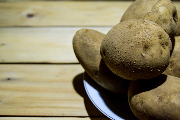 Close-up Fresh potatoes lying on wooden table