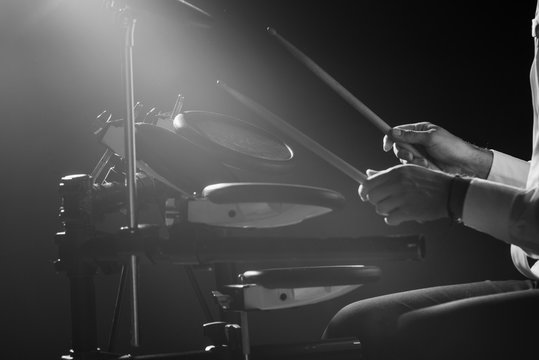 Drummer. The guy holds drum sticks in his hand against the background electronic drum. Young man with drum sticks.  