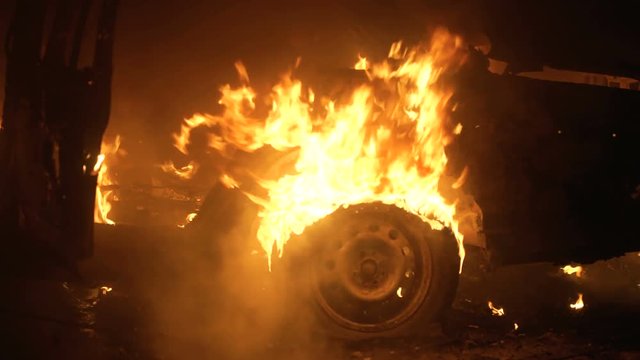 A wheel burns in a car at night, car tires burn.