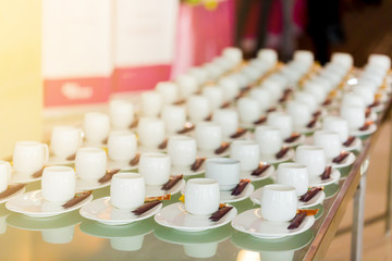 A lot of white coffee cups and brown sugar in the seminar with blurred background.