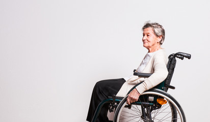 Obraz premium Portrait of a senior woman with wheelchair in studio.