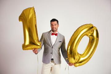 Young man with golden balloon building the figure 