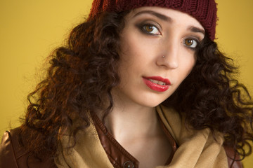 attractive girl in a brown leather jacket in the studio