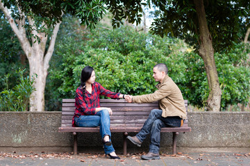 公園のベンチに座るカップル