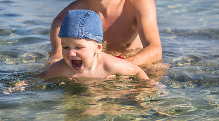 Dad teaches to swim son, toddler's little cute boy