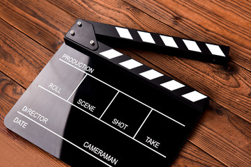 Film slate or movie clapper board on wooden background