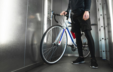 Close-up photo of cyclist's foot and highway bike in the elevator. Cyclist lives in a high-rise...