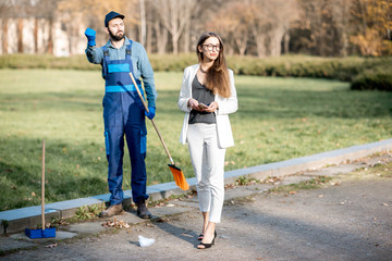 Businesswoman threw garbage with arrogant attitude near the man sweeping the street. Poverty and...