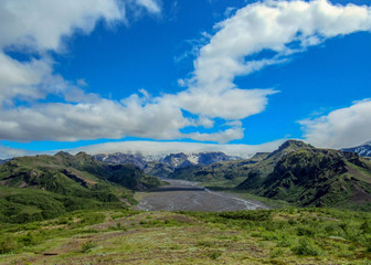 Fototapeta premium Green valley of Thorsmork, with volcanoes, glaciers, green forest and blue sunny sky in summer day, Highlands of Iceland, Europe