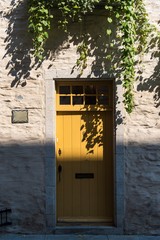 old yellow wooden door on stone house