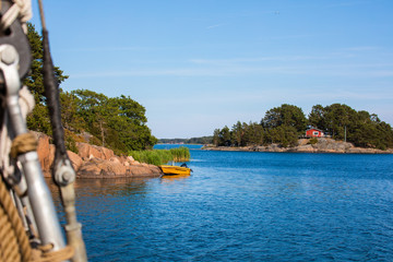 A moored orange motor boat on the rocky shore of the scenic and beautiful Island of Nicklösa in the Åland Islands, Finland, in the Baltic Sea.