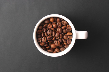  coffee beans in a cup on a dark background, top view.