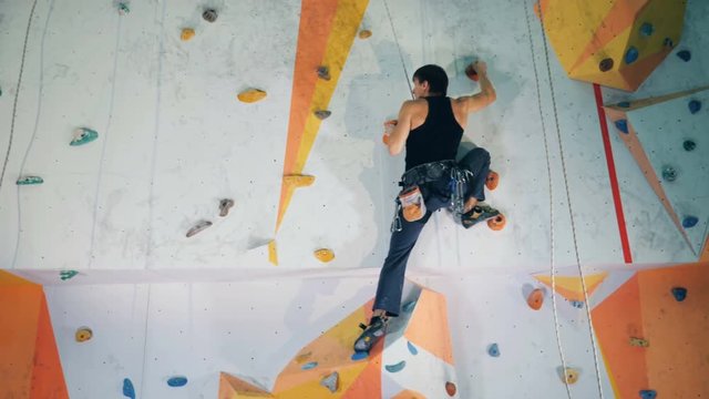 Person on a climbing wall with special equipment, close up.