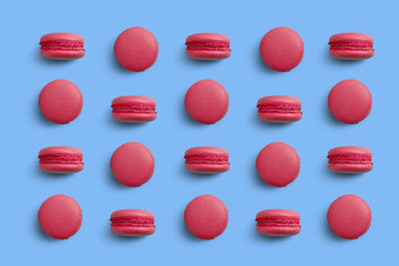 Macaroons on colored background, a pattern of colorful french cookies macarons. Beige, brown french cookies macarons on red background. Gift for Valentine's Day