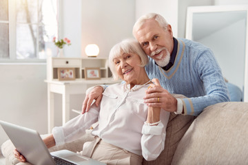 Beautiful couple. Elderly beautiful couple spending weekend while watching photos at the laptop
