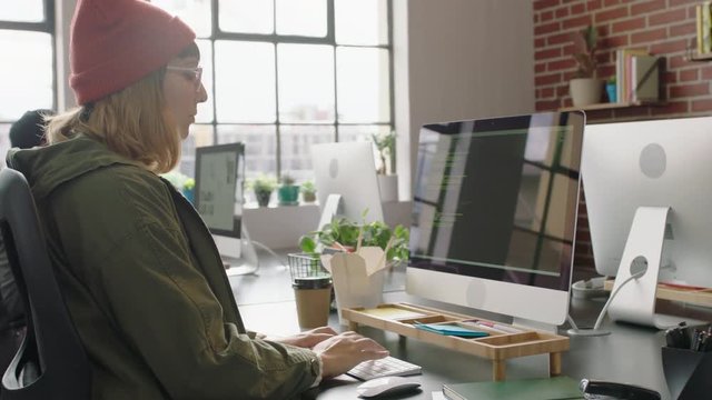young caucasian woman programmer coding network security software for startup company professional web developer typing code on computer screen in modern startup office 