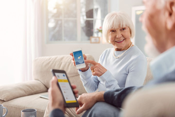 Send a message. Couple of grey-haired baby boomers exchanging messages on the smartphones while...