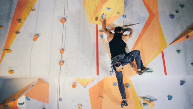 A person on a dangerous climbing wall, close up.