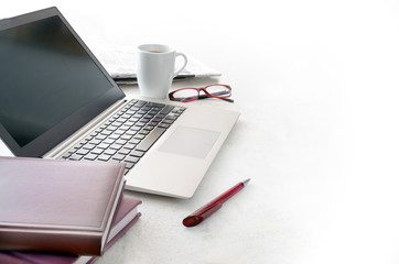 office desk with laptop, calendar , glasses and a cup of coffee on a bright surface, background fades to white, copy space