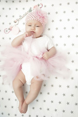 A Baby girl in white bedding at home look nice. learning newborn