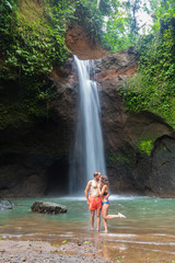 Fototapeta na wymiar couple looking at the gorgeous waterfall in Bali