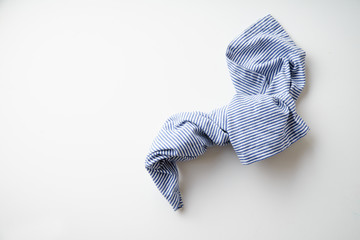 Striped blue and white textile napkin folded on white background. Food styling element
