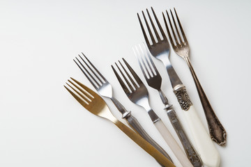 Various vintage forks on white background with copy space