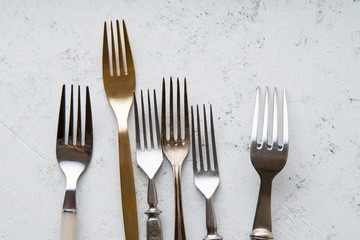 Various vintage forks on concrete background with copy space