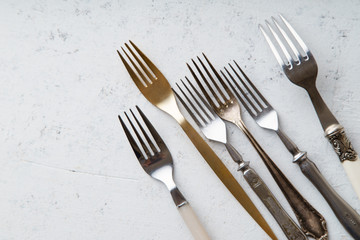 Various vintage forks on concrete background with copy space