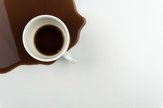 Top View Of A Cup Of Coffee And Spilled Coffee On The White Table