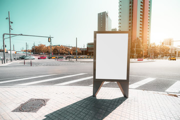Outdoor empty informational board placeholder with a road junction behind; a blank advertising...