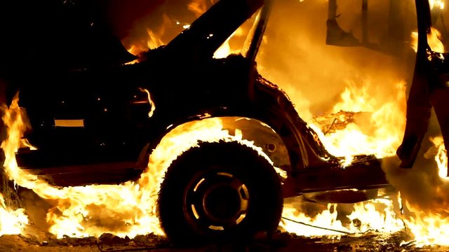 Burning car body, burning iron, broken car on fire
