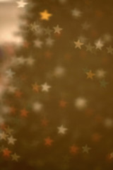 Defocused Christmas tree with star shaped bokeh. Festive holiday background.