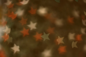 Defocused Christmas tree with star shaped bokeh. Festive holiday background.