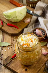 Sauerkraut variety preserving jars. Homemade Sauerkraut with Carrot on a wooden table. Fermented...