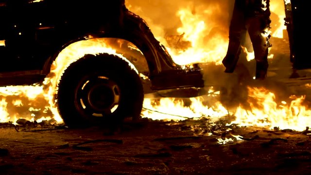 Broken car burns after an accident. The explosion and fire of the car. Side view