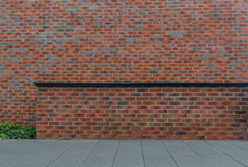 red brick wall with a fragment of the pavement