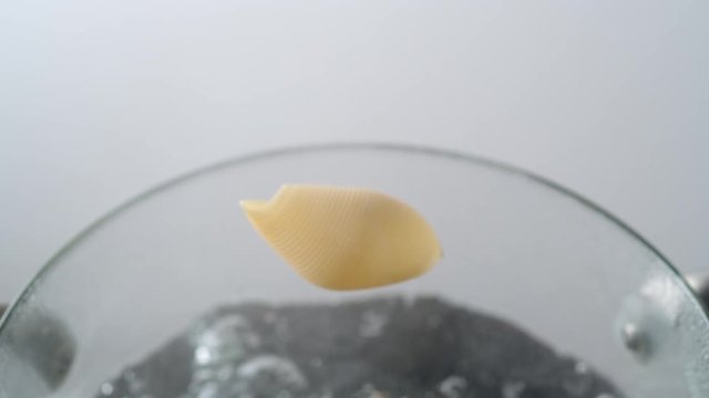 Camera follows cooking shell noodles in boiling water. Shot with high speed camera, phantom flex 4K. Slow Motion.