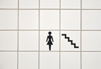 sign of a woman and stairs referring to the bathroom or toilet
