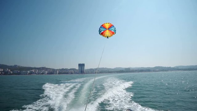 Excited tourists parasailing high in the sky, extreme sport, summer activities