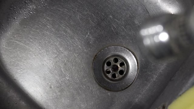 View of the sink, drain and dripping water, background loop
